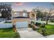 Two-story house with attached garage, landscaping, and a white fence at 8115 61St N St, Pinellas Park, FL 33781