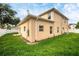 Tan two-story house with a grassy backyard and white fence at 8115 61St N St, Pinellas Park, FL 33781
