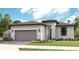 Single-story home with a two-car garage and attractive landscaping at 14370 Hammock Oak St, Parrish, FL 34219