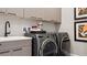 Modern laundry room with updated washer, dryer, and cabinetry at 14370 Hammock Oak St, Parrish, FL 34219