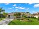 Single-story house with a two-car garage and palm trees in the front yard at 15392 Taurus Cir, Port Charlotte, FL 33981