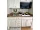 Small galley kitchen with white cabinets, microwave, and two-burner cooktop at 1420 Bayshore Blvd # 316, Dunedin, FL 34698