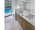 Updated bathroom with dual sinks, a bathtub, and a view of the pool at 6826 San Jose Loop, New Port Richey, FL 34655