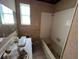 A bathroom with white tile, a tub and a single sink, needs updating at 16211 3Rd E St, Redington Beach, FL 33708