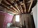 Unfinished bedroom with exposed ceiling beams and damaged walls at 16211 3Rd E St, Redington Beach, FL 33708