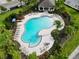 Aerial view of community pool with lounge chairs and a covered patio at 1403 Custer Bayou St, Ruskin, FL 33570