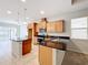 Open kitchen with island, granite countertops, and wood cabinets at 1403 Custer Bayou St, Ruskin, FL 33570