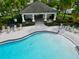 Community pool with adjacent covered patio and lounge chairs at 1403 Custer Bayou St, Ruskin, FL 33570