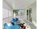 Relaxing screened porch with blue velvet chairs and a cowhide rug at 2246 Goldenrod St, Sarasota, FL 34239