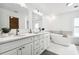 Modern bathroom with double vanity, large soaking tub, and grey tile at 72 Windsor Dr, Englewood, FL 34223