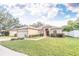 One-story house with a red door and attached garage, nestled on a spacious lawn at 12908 Cattail Shore Ln, Riverview, FL 33579