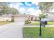Tan one-story house with a red door, two-car garage, and well-manicured lawn at 12908 Cattail Shore Ln, Riverview, FL 33579