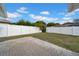 Private backyard with a brick patio and a white fence at 5116 Lillilea Ln, New Port Richey, FL 34653