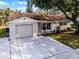 Newly renovated tan house with a brown roof and attached garage at 7939 Riverdale Dr, New Port Richey, FL 34653