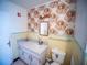 Small bathroom with vintage wallpaper, sink, and toilet at 38906 North Ave, Zephyrhills, FL 33542