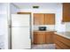 Kitchen area with white refrigerator and wood cabinets at 4137 Glissade Dr, New Port Richey, FL 34652