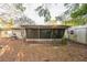 Backyard view of a screen porch with wood pile at 4137 Glissade Dr, New Port Richey, FL 34652