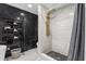 Luxurious bathroom featuring sleek black and white marble tile and a modern gold shower system at 1390 Eastfield Dr, Clearwater, FL 33764