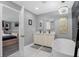 Luxurious bathroom featuring sleek black marble tile, a modern gold shower system, a freestanding tub, and a double sink vanity at 1390 Eastfield Dr, Clearwater, FL 33764
