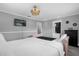 Bedroom featuring a pink bed frame with plush white linens and a modern ceiling fan, and an ensuite bath at 1390 Eastfield Dr, Clearwater, FL 33764