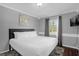 Comfortable bedroom features hardwood floors, a plush white bed, and lots of natural light at 1390 Eastfield Dr, Clearwater, FL 33764