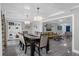 Open concept Dining Room with a long table and views to the living room and blue front door at 1390 Eastfield Dr, Clearwater, FL 33764