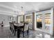 Bright dining room featuring hardwood floors, a modern chandelier, and sliding door access to the outdoor pool at 1390 Eastfield Dr, Clearwater, FL 33764