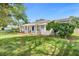 Single story home with a white picket fence porch, side lawn and colorful landscaping at 1390 Eastfield Dr, Clearwater, FL 33764