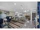 A spacious living room with stylish furniture, decor, and sleek gray flooring open to kitchen and dining at 1390 Eastfield Dr, Clearwater, FL 33764