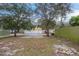 Spacious backyard with trees and a partially paved area at 7707 N Riverdale Ave, Tampa, FL 33604