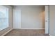 Well-lit bedroom with carpet, window, closet, and neutral walls at 7707 N Riverdale Ave, Tampa, FL 33604
