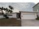 Front view of mid-century modern home with attached garage at 11240 6Th E St, Treasure Island, FL 33706