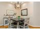 Bright dining area with a square table, four chairs, and a stylish light fixture at 7313 Emma Rd, Bradenton, FL 34209