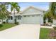 Light green house with a two-car garage and landscaped lawn at 7313 Emma Rd, Bradenton, FL 34209