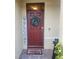 Red front door with a welcome wreath and mat at 109 Tierra Verde Way, Bradenton, FL 34212