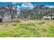 Open land with some debris and distant view of the home at 6936 Handcart Rd, Wesley Chapel, FL 33545