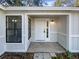 Front entryway with white door and black framed windows at 1505 Larkin Rd, Spring Hill, FL 34608