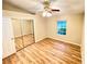 Bright bedroom with mirrored closet doors and wood-look floors at 2105 Vickery Ln, Dover, FL 33527