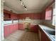 Pink kitchen with a double sink and wall cabinets at 37921 Tiffany Rd, Dade City, FL 33525