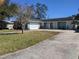 Light teal house with a double garage and well-manicured lawn at 2057 Little Neck Rd, Clearwater, FL 33755