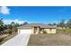 House exterior featuring a yellow single-story home with a two-car garage and driveway at 7864 Jayman Rd, North Port, FL 34291