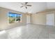 Living room with tile floors, a large window, and a ceiling fan at 7864 Jayman Rd, North Port, FL 34291