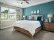 Relaxing bedroom with large windows and a teal accent wall at 124 Runaway Field Ave, Nokomis, FL 34275