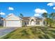 Front view of a single-story house with a white exterior, a two-car garage, and a green lawn at 14248 Salvatierra Ln, Port Charlotte, FL 33981