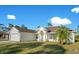 Single-story house with a white exterior, a two-car garage, and a landscaped yard at 14248 Salvatierra Ln, Port Charlotte, FL 33981