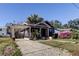 Gray bungalow with a brick driveway and lush landscaping at 7108 N 10Th St, Tampa, FL 33604