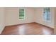 Well-lit bedroom featuring wood-look floors and dual windows at 7495 Mitchell Rd, Brooksville, FL 34601