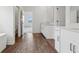 Double vanity bathroom with dark wood-look flooring and a view into another room at 8796 Little Bluestem Dr, Land O Lakes, FL 34637