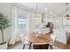 Modern dining area with wood table and view into kitchen at 8796 Little Bluestem Dr, Land O Lakes, FL 34637