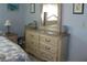 Bedroom with dresser and nightstand, featuring a coastal-themed bedding set at 1000 Osceola Blvd, Englewood, FL 34223